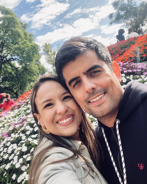 Natalia y Carlos sonriendo juntos entre flores